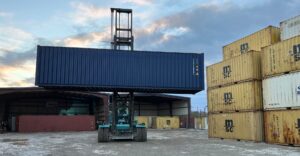 a shipping container being moved by a forklift