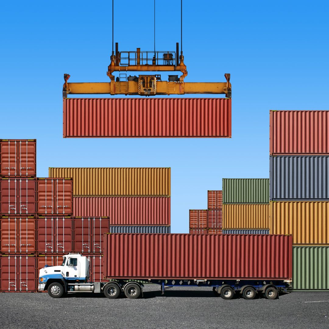Container being lifted by crane and placed onto a truck bed
