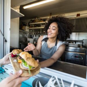 Lady handing customer food from her food truck