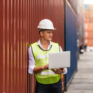 man with laptop at shipping container location