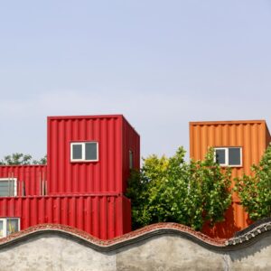 red and orange metal structures with windows and sky in the background