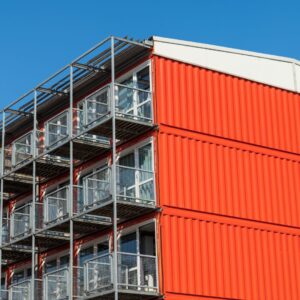 stacked red shipping containers with glass doors and patios built off the end