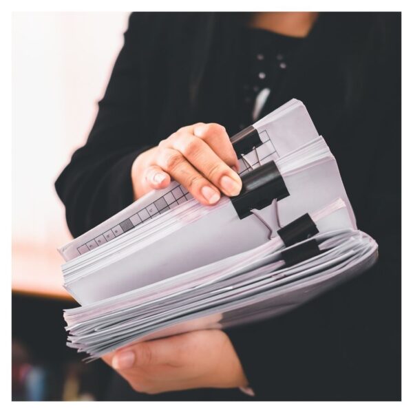 holding a stack of paperwork