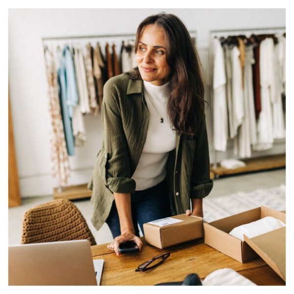 small business owner with clothing racks behind her