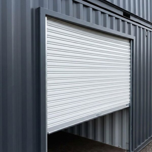 a partially open white roll-up door on a dark grey container