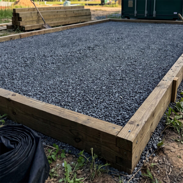 A level gravel foundation prepared for a shipping container.
